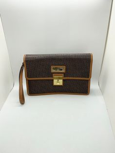 "This is a Ted Lapidus, Paris, designer clutch or wristlet swing purse.  The exterior is the classic pattern of dark brown textured squares trimmed with golden brown leather and gold tone accents.  Exterior markings include \"TED LAPIDUS PARIS\" on the front gold nameplate and \"TL\" on the rivet securing the wristlet.  The fold over flap cover snaps in and secures easily.  It opens smoothly when the little gold button is pulled down. The interior is finished with \"TED LAPIDUS\" stamped fabric Open Business, Stamped Fabric, Hummingbird Gifts, Ted Lapidus, Pencil Holders, Fabric Stamping, Brown Texture, Leather Tag, Designer Clutch