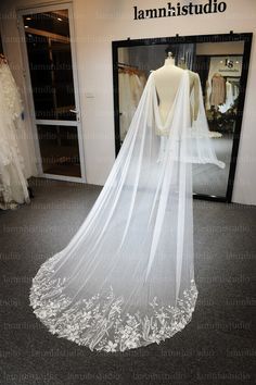 a white wedding dress on display in front of a mirror