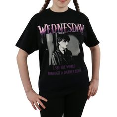 Step into the darkness with style wearing this Wednesday Addams womans t shirt. Crafted from 100% cotton, this ladies t shirt in black features a striking depiction of Jenna Ortega as the unapologetic and sarcastic Wednesday, the beloved personality from the Addams Family. The title logo 'Wednesday' is prominently displayed above her in a dark purple, while the iconic quote "I see the world through a darker lens" is written in vivid purple for the perfect grunge top for teen girl clothes. Perfec Wednesday Merchandise, Deadpan Expression, Wednesday Tshirt, Addams Family Shirt, Goth Goddess, Gothic Wardrobe, Edgy Teen, Wednesday Outfit, Addams Familie