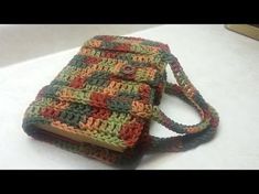 a crocheted book bag sitting on top of a table