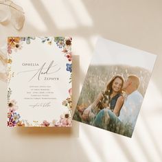 an open photo album with flowers on it next to a card that says ophela and zeppyr