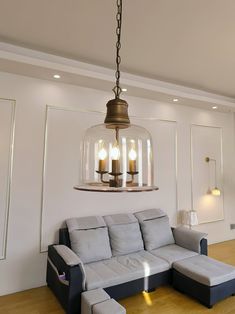 a living room filled with furniture and a chandelier hanging over the top of it