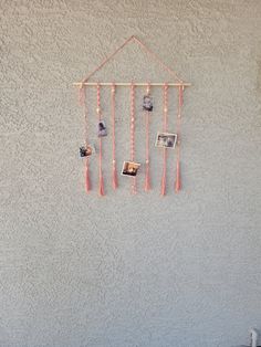 a wall hanging on the side of a building with pictures and photos attached to it