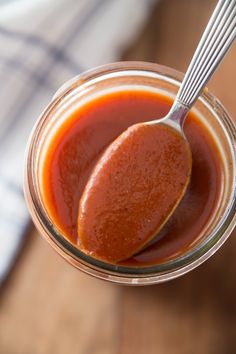 a spoon full of ketchup sitting in a jar