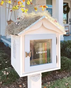 a white bird house with books in it