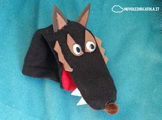 an animal head made out of felt on a blue cloth with red tongue and mouth