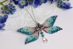 A must-have for all fairies! A unique and truly beautiful blue sparkle fairy pendant. This necklace is embellished with silver sparkle, gems and a silver charm. The wings measure approximately 10.5cm across. This delicate array of fairy wings is really rather lovely. It is perfect for all fairy lovers - whether to be worn as part of a costume, or simply as a pendant for everyday wear. It is super light weight, and the wings are slightly flexible to touch. These wings are far more durable than th Blue Fairy Jewelry For Party, Blue Fairy-style Jewelry For Party, Handmade Blue Fairycore Jewelry, Beaded Butterfly, Handmade Fairy, Fairy Pendant, Fairycore Fairy, Wing Jewelry, Mori Kei