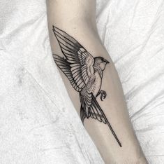 a black and white bird tattoo on the arm