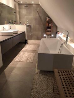 a large bathroom with two sinks and a bathtub in the middle of the room