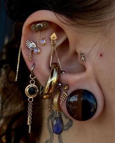 a woman with ear piercings and jewelry on her ears, looking to the side