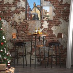 a brick wall with two stools in front of it and a painting on the wall