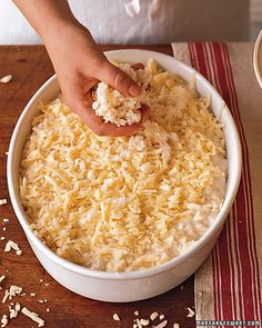 a person scooping food out of a bowl on top of a wooden cutting board