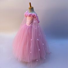 Elevate your little one's special moments with this dreamy soft pink ball gown dress. Perfect for toddler girls and baby girls, this enchanting dress features an off-the-shoulder design adorned with exquisite handcrafted flowers, adding a touch of elegance and whimsy. The sweetheart neckline gracefully frames the face, while the back showcases a charming corset-style closure, ensuring a snug and adjustable fit. Flowing gracefully to ankle length, the gown boasts layers of ethereal tulle that create a beautiful, voluminous silhouette. Ideal for princess-themed parties, weddings, or any occasion where a touch of magic is desired. Let your little princess shine in this timeless and sophisticated dress. Size Guide: 1) All our Gowns can be made in any size ranging from girls 3-6 months to Adult Pink Ball Gown Princess Dress For Debutante Ball, Pink Ball Gown For Debutante Ball, Pink Princess Dress For Debutante Ball, Pink Princess Gown For Debutante Ball, Tulle Pageant Dress For Debutante Ball, Pink Princess Style Dress For Debutante Ball, Pink Tulle Pageant Dress For Debutante Ball, Pink Tulle Pageant Dress For Wedding, Pink Tulle Skirt Pageant Dress For Wedding