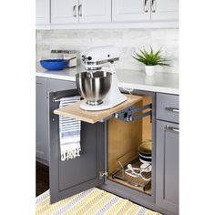 an open cabinet in a kitchen with a mixer on the counter and other items inside