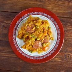 a red and white plate topped with rice and sausage