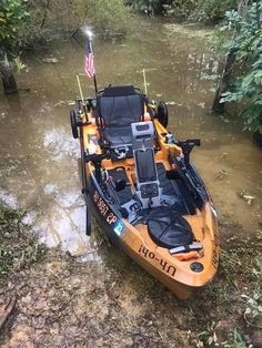 an orange and black boat in the water with american flag on it's side