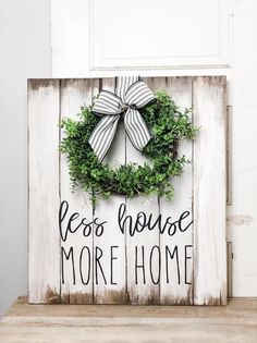 a wooden sign with a wreath on it that says, let's house more home