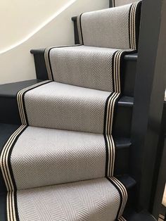 some stairs with black and white striped carpet