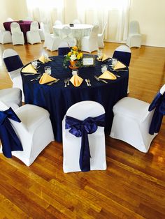 the table is set up with white chairs and blue cloths for an elegant event