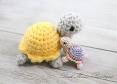 two small crocheted animals are next to each other