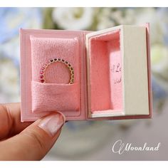 a pink box with a ring in it that is open to show the inside and outside