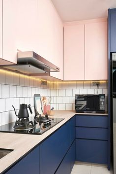 a kitchen with blue cabinets and white counter tops