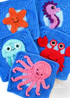 four crocheted coasters with sea animals on them, one is blue and the other has red