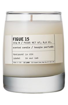 a white candle with a label on it that says figue 15 in front of a white background