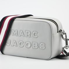 Single Detachable, Adjustable Crossbody Strap - Approx. 12.5-25" Strap Drop Zip-Top Closure Exterior Features Large Brand Logo Detail Interior Features 1 Slip Pocket, Printed Lining Approx. 6.5" H X 8.5" W X 3" D Style Marc Jacobs M0014465 - Flash Leather Crossbody Bag In Light Grey Designer Crossbody Bag With Embossed Logo, White Travel Shoulder Bag With Embossed Logo, White Shoulder Bag With Embossed Logo For Travel, Elegant White Bags With Logo Strap, White Bag With Logo Strap For Shopping, White Shopping Bag With Logo Strap, White Bags With Logo Strap For Shopping, Modern Crossbody Bag With Embossed Logo, Crossbody Shoulder Bag With Embossed Logo