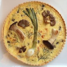 a quiche with mushrooms and herbs on it