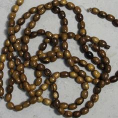 some brown beads are laying on the ground and ready to be used as necklaces