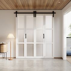 an empty room with sliding glass doors and a lamp on the floor in front of it