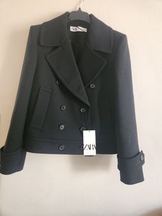 Get ready to turn heads with this stunning Zara double-breasted wool short coat/jacket in black, size M. The classic fit and solid pattern make it perfect for any occasion, from travel to business meetings. The jacket features a button closure and long sleeves, making it suitable for fall, winter, and spring seasons. Made from a high-quality blend of 64% polyester, 35% wool, and 1% elastane, the outer shell material gives the jacket a luxurious look and feel. The coat also comes with a 100% viscose lining material to keep you warm and comfortable. This stylish pea coat has all the qualities of a wardrobe staple and is a must-have for any fashion-savvy woman. Wool Short Coat, Short Coat Jackets, Pea Coat, Short Coat, Spring Season, Solid Pattern, Wardrobe Staples, Vest Jacket, Double Breasted