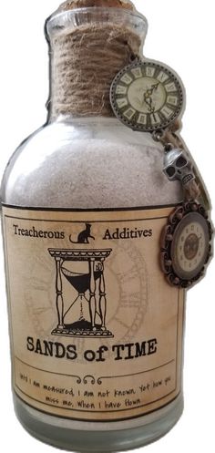 a bottle filled with sand sitting on top of a white table next to a clock