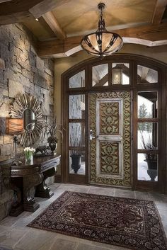 an ornate door and rug in front of a stone wall