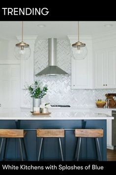 a kitchen with white cabinets and blue stools in front of an island countertop