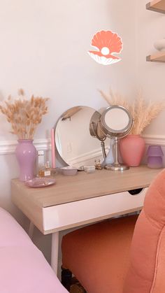 a pink chair sitting next to a desk with a mirror on it