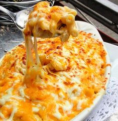 a white plate topped with macaroni and cheese covered in melted cheddar