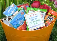 a basket filled with lots of different types of candy and candies on top of green grass