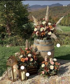 an arrangement of flowers and candles on top of a table in front of a mountain