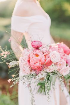 a bride holding a bouquet of pink flowers