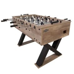 a wooden foosball table with black and white chess pieces on it's legs