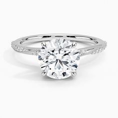 a round cut diamond ring with pave set shoulders