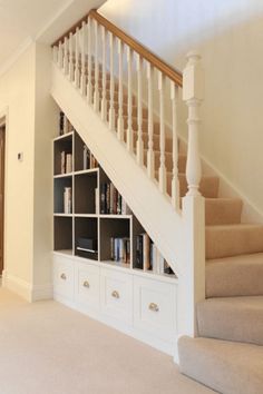 a staircase with bookshelves and drawers under the bannister in a house