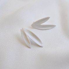 two pieces of white plastic sitting on top of a bed