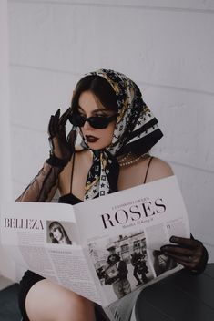 a woman sitting down reading a magazine