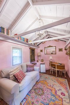 a living room filled with furniture and pink walls