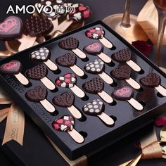 an assortment of heart shaped chocolates in a black box