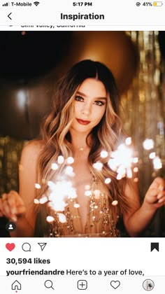 a woman holding sparklers in her hand and looking at the camera with an instagramr