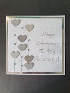 a happy anniversary to my husband card with hearts hanging from the strings and words on it